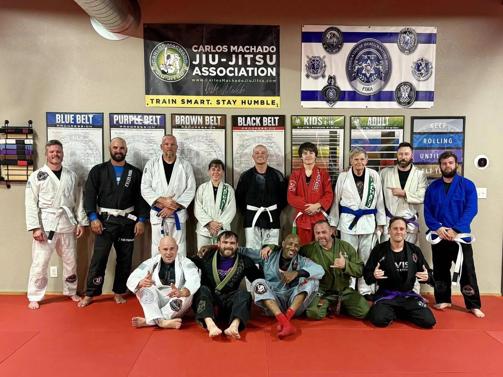 Teen and adult students with their instructor after a belt promotion at Davis Martial Arts & Fitness in Pilot Point