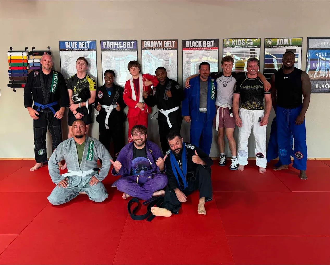 The adult Brazilian Jiu-Jitsu class gathered on the red mat, some in gis and some in no-gi gear, at Davis Martial Arts & Fitness in Pilot Point, TX