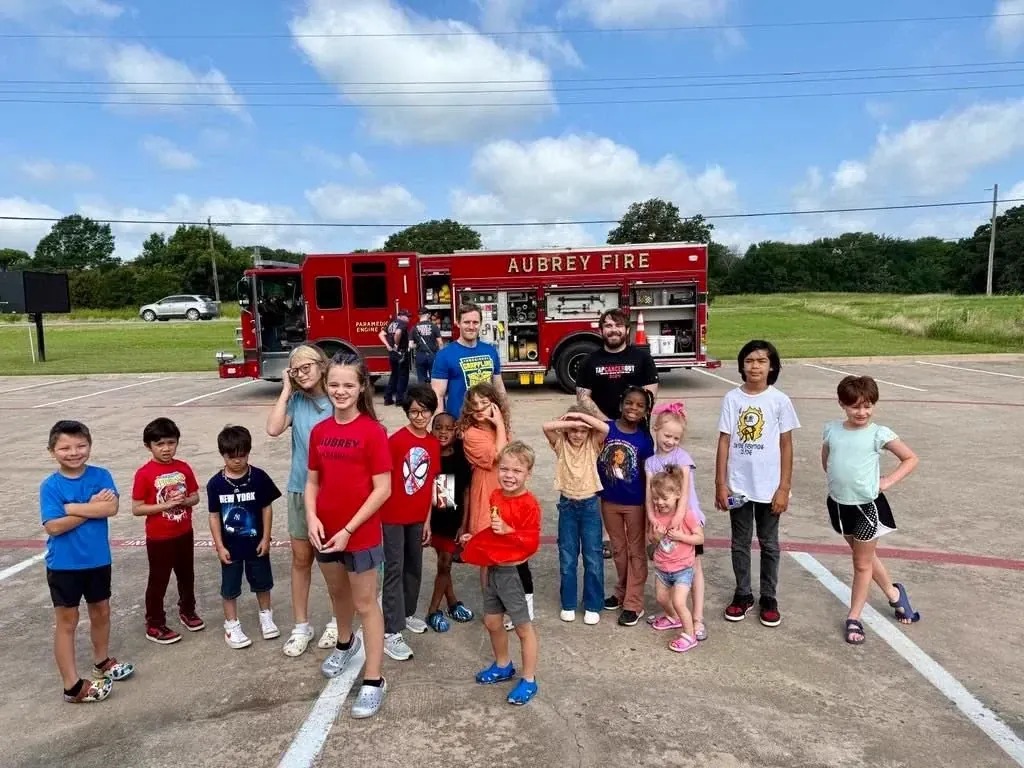 Summer camp kids posing in front of the Aubrey fire truck on a field trip with Davis Martial Arts & Fitness