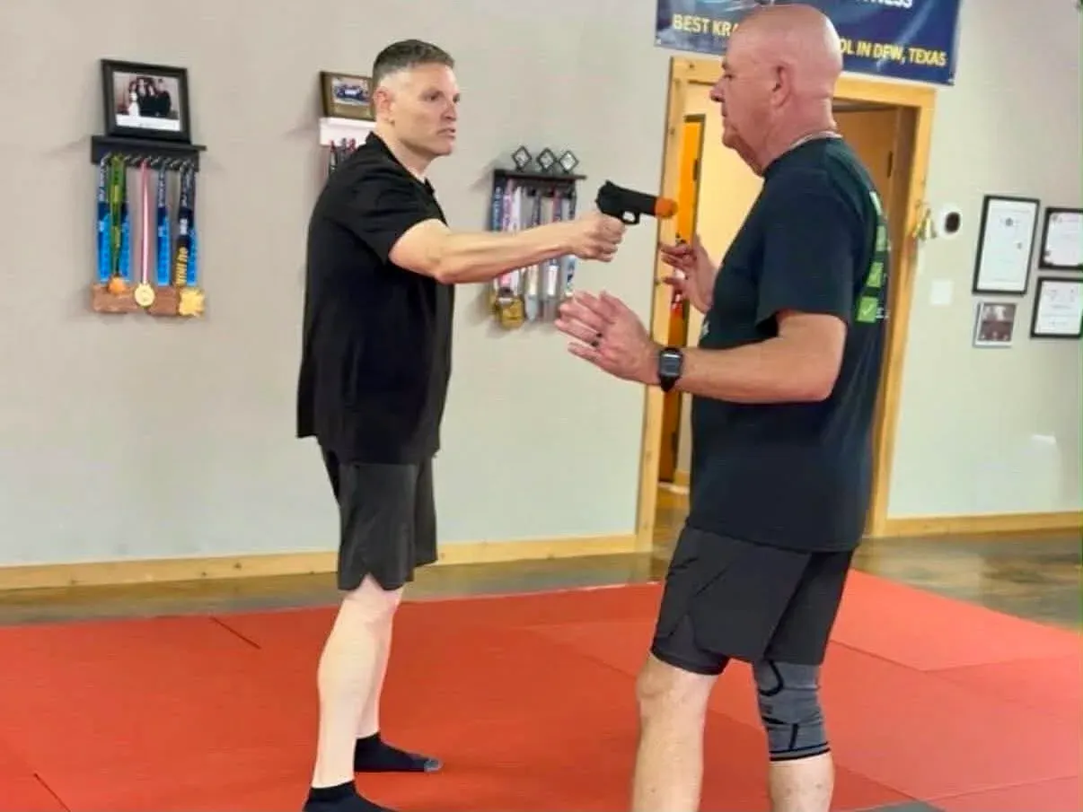 Two adults drilling a handgun threat defense during Krav Maga class at Davis Martial Arts & Fitness in Pilot Point, TX