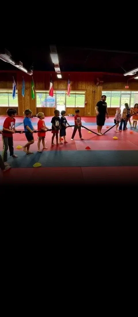 Summer camp kids in a tug-of-war line game at Davis Martial Arts & Fitness in Pilot Point, TX