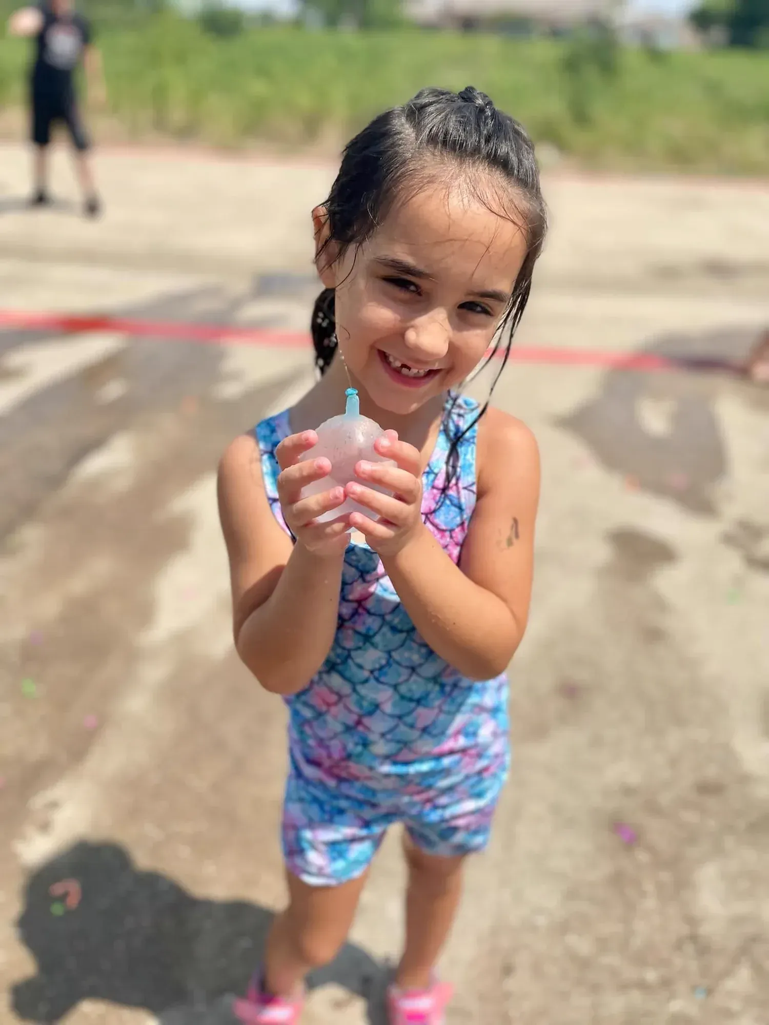 Two summer camp kids smiling with water balloons outside at Davis Martial Arts & Fitness in Pilot Point, TX