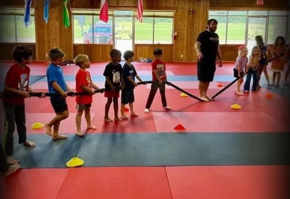 Summer camp kids playing a tug-of-war game at Davis Martial Arts & Fitness in Pilot Point, TX