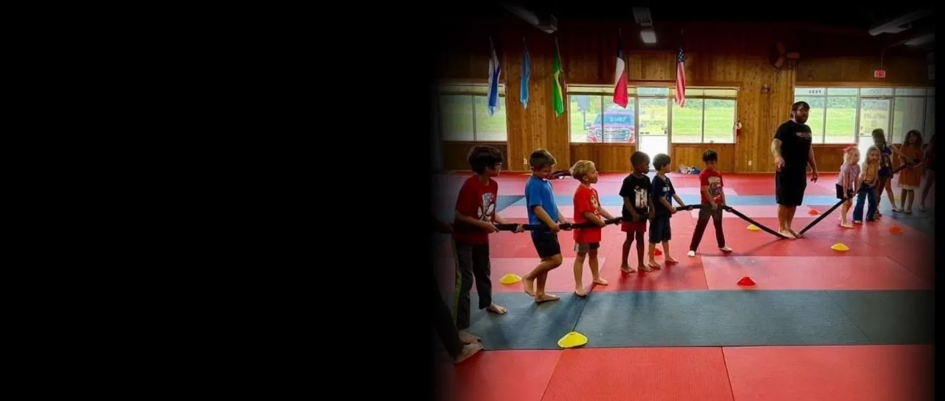 Summer camp kids playing a tug-of-war game at Davis Martial Arts & Fitness in Pilot Point, TX