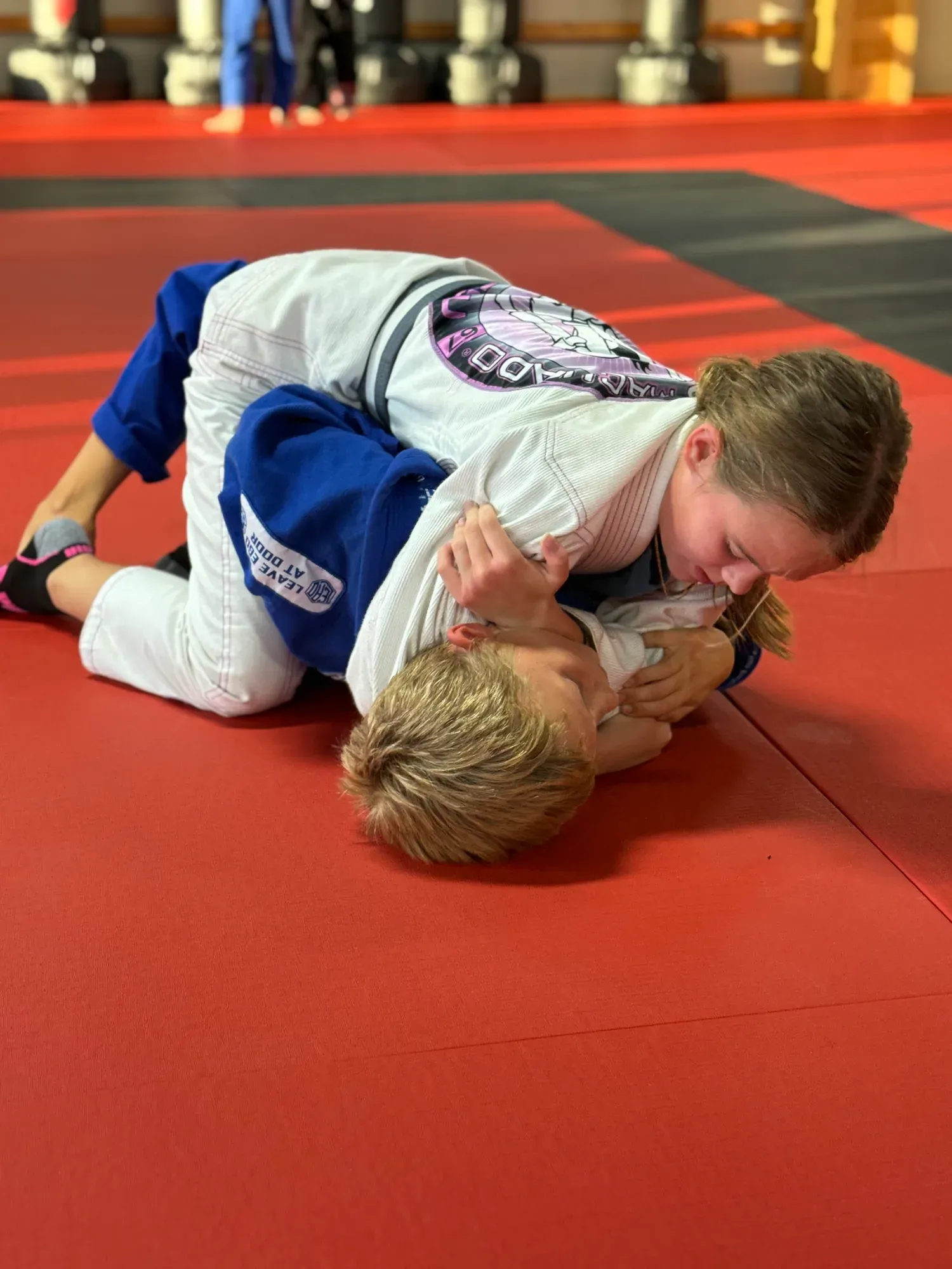 Two young students in gis training together on the mat during class at Davis Martial Arts & Fitness in Pilot Point, TX