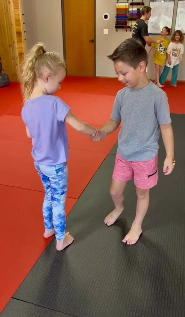 Young student in martial arts uniform standing tall and confident in a dojo